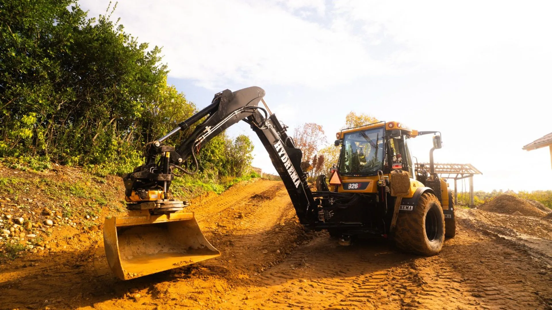 Tractopelle sur une piste de terre, chantier de terrassement