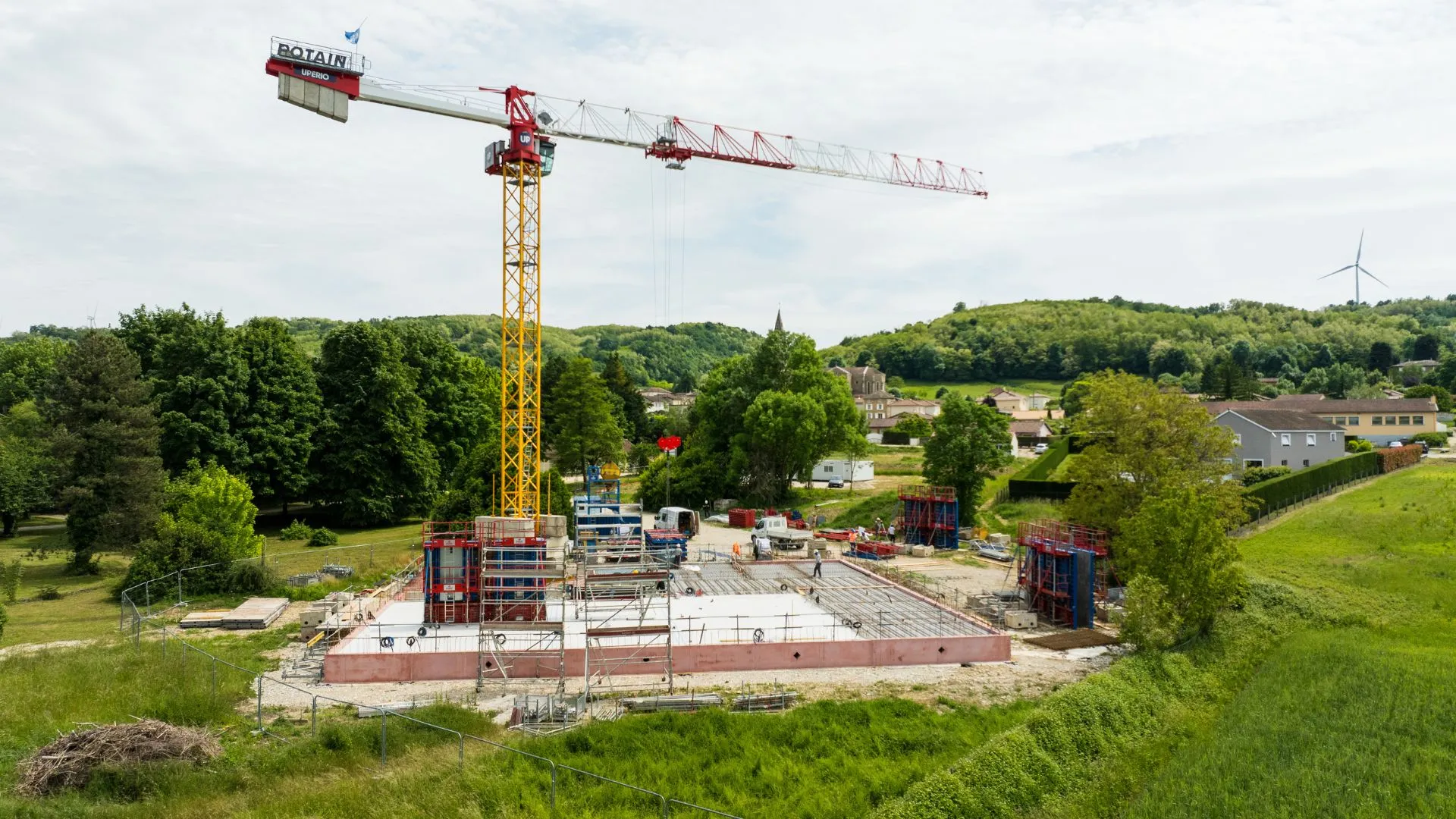 Grue et fondations d'un chantier dans un paysage verdoyant