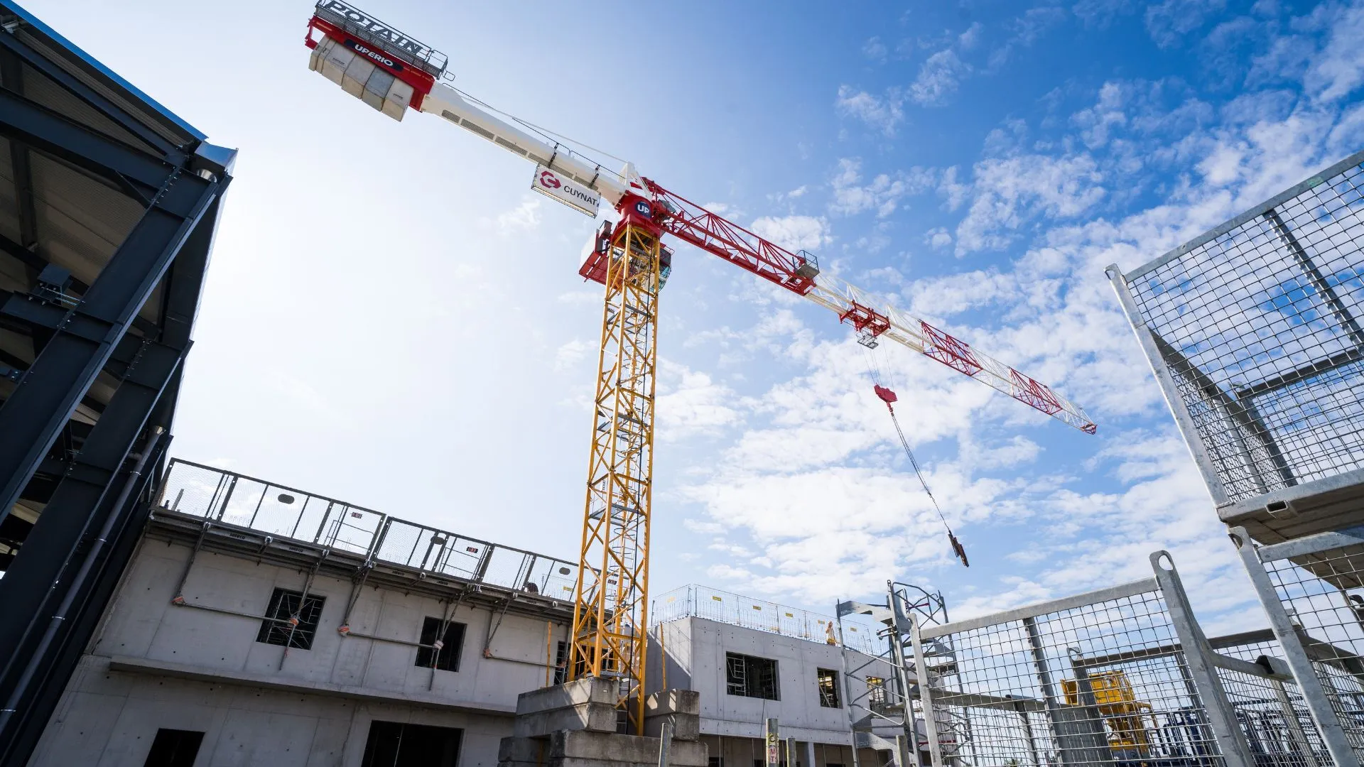 Grue rouge dressée au-dessus d'un chantier de bâtiment