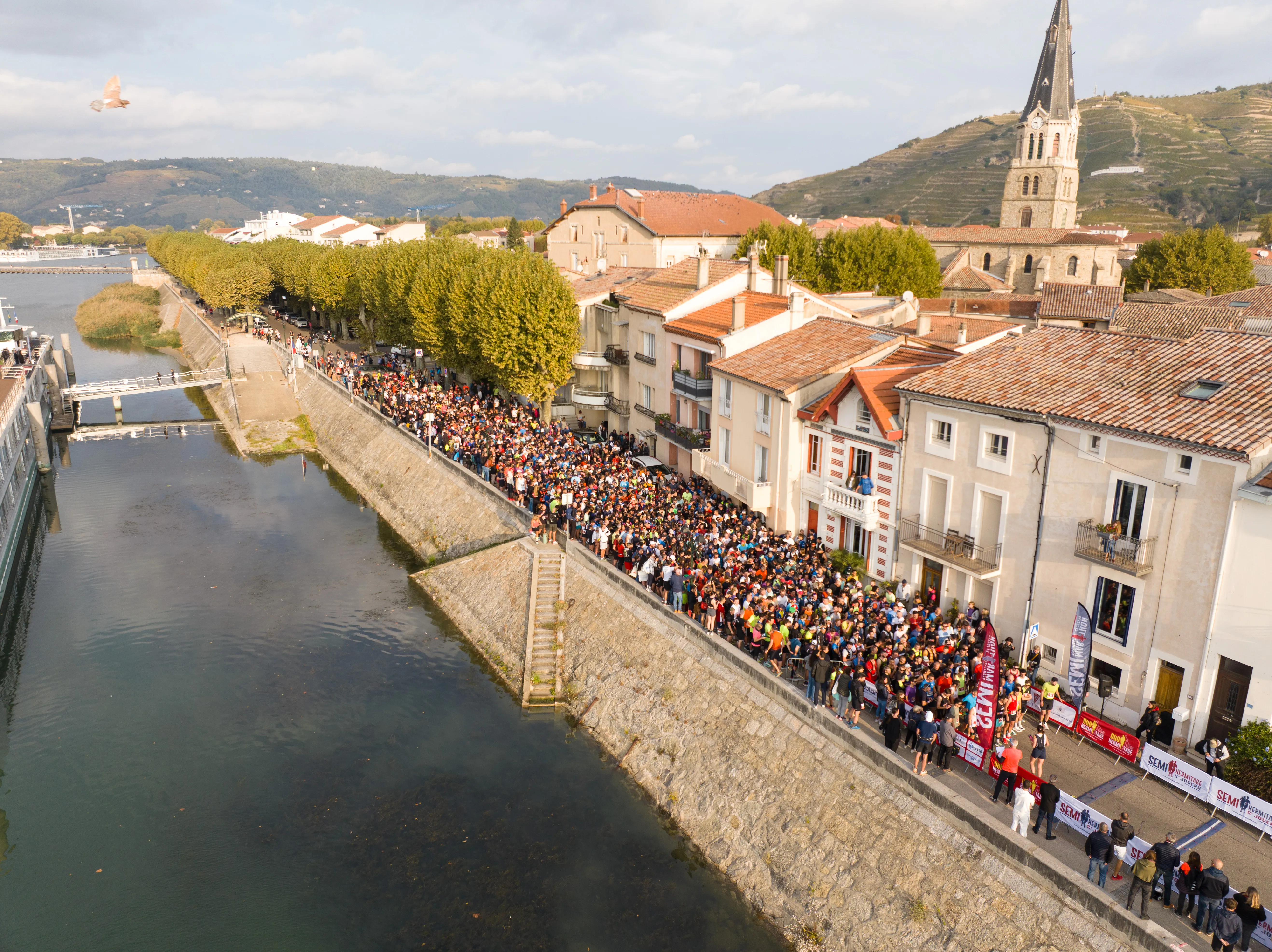 Vue aérienne du départ d'un semi-marathon, foule massée sur les quais du Rhône