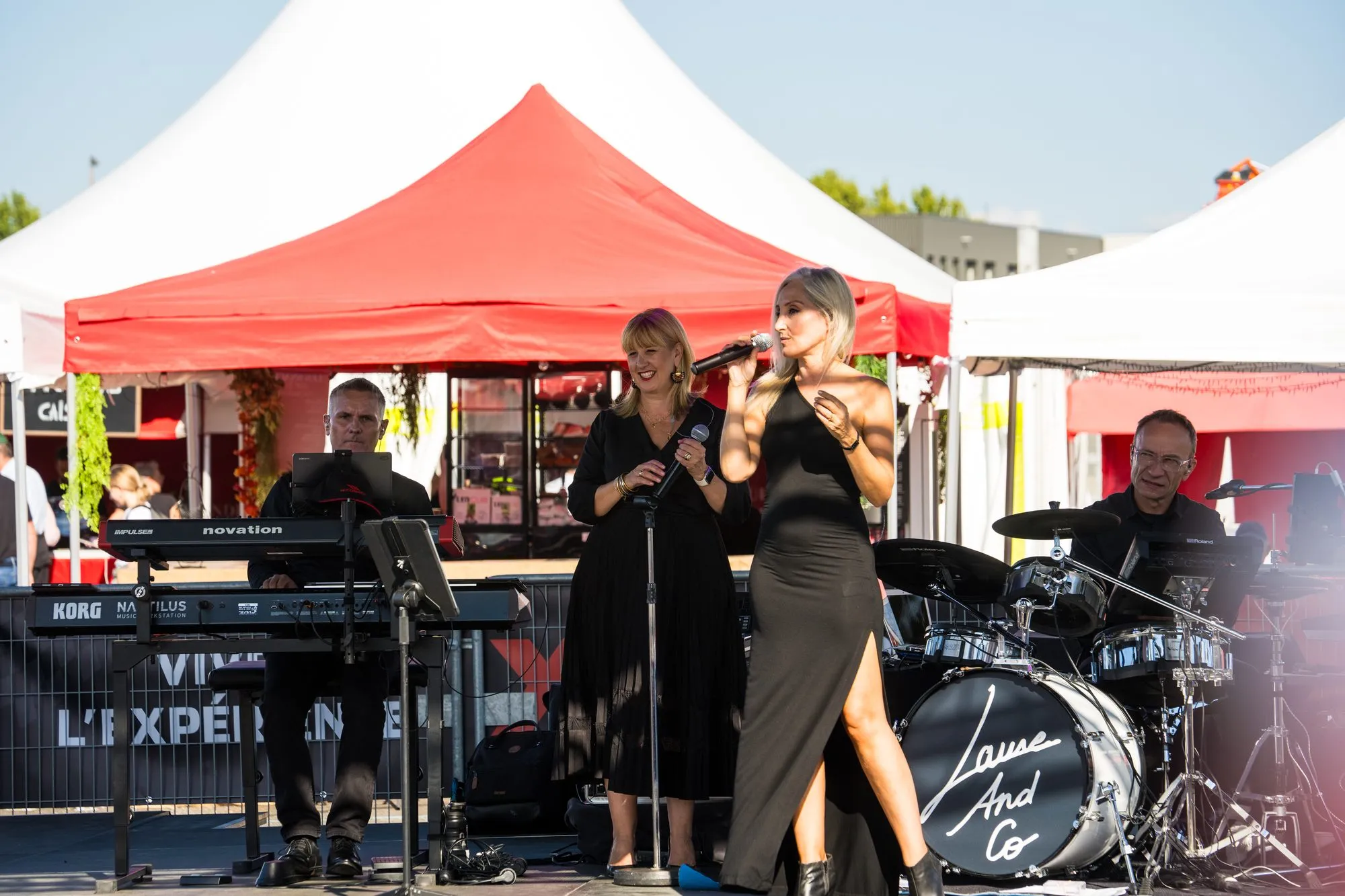 Concert live sur la scène du stand McCormick, chanteuses et musiciens sous les barnums rouges
