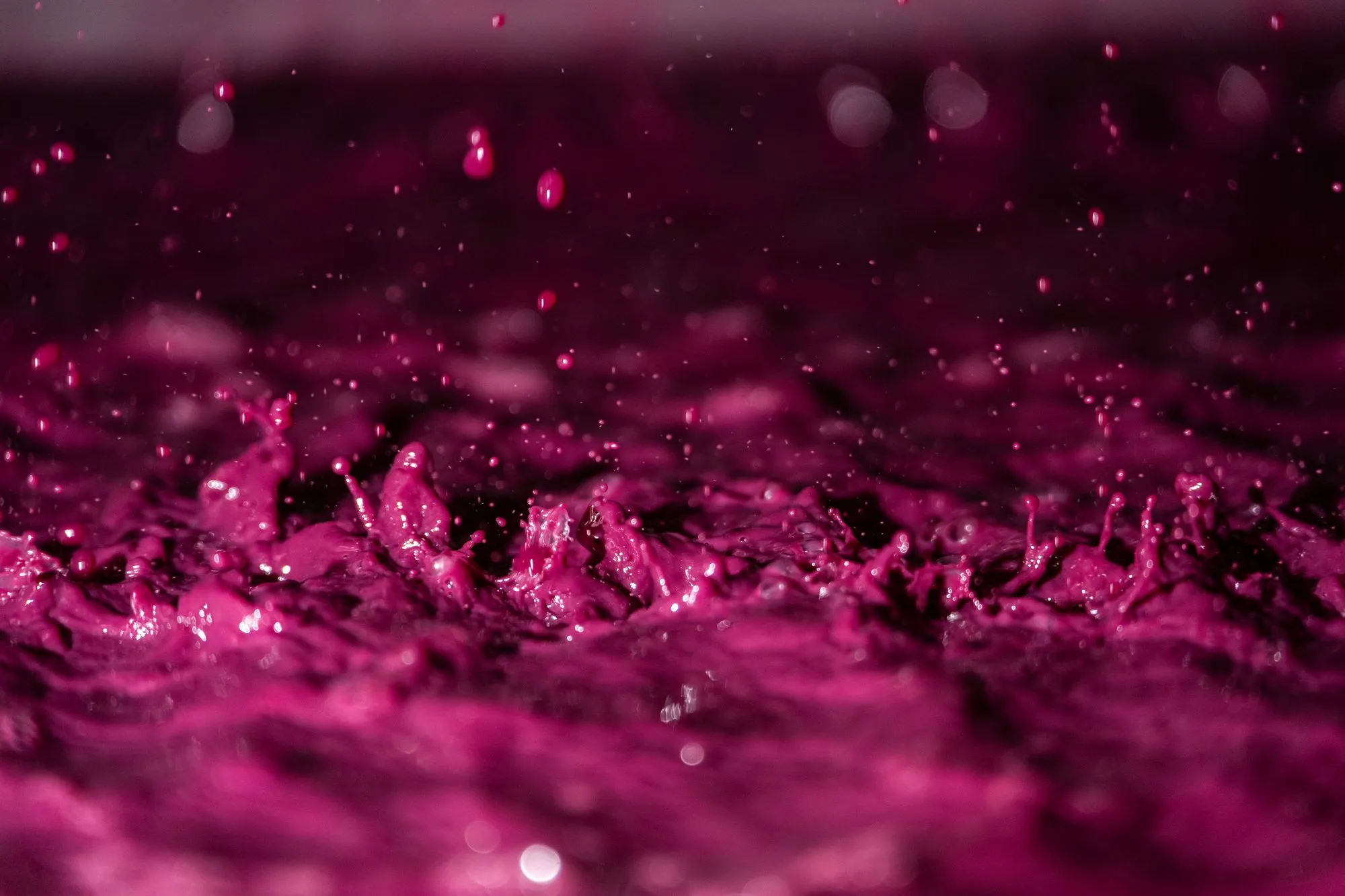 Jus de raisin rosé en mouvement, gouttes et éclaboussures en gros plan