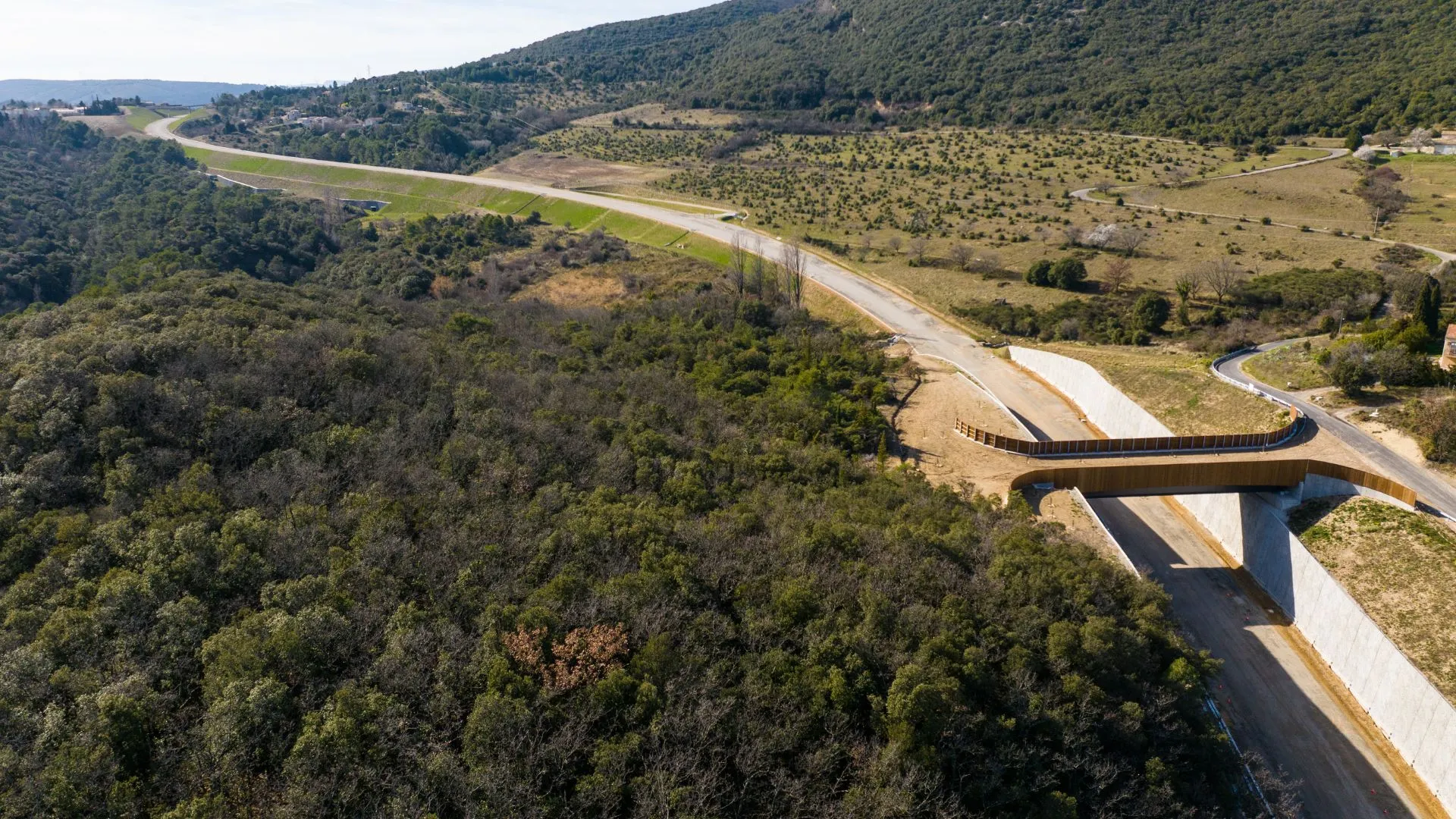 Vue aérienne de la route neuve et d'un passage faune au-dessus de la forêt