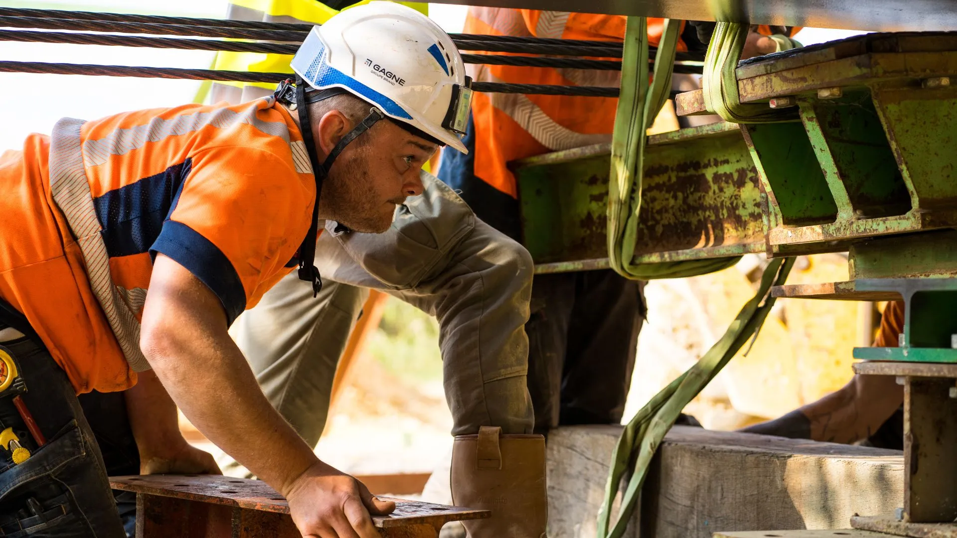 Ouvrier concentré sous un ouvrage métallique, reportage de chantier