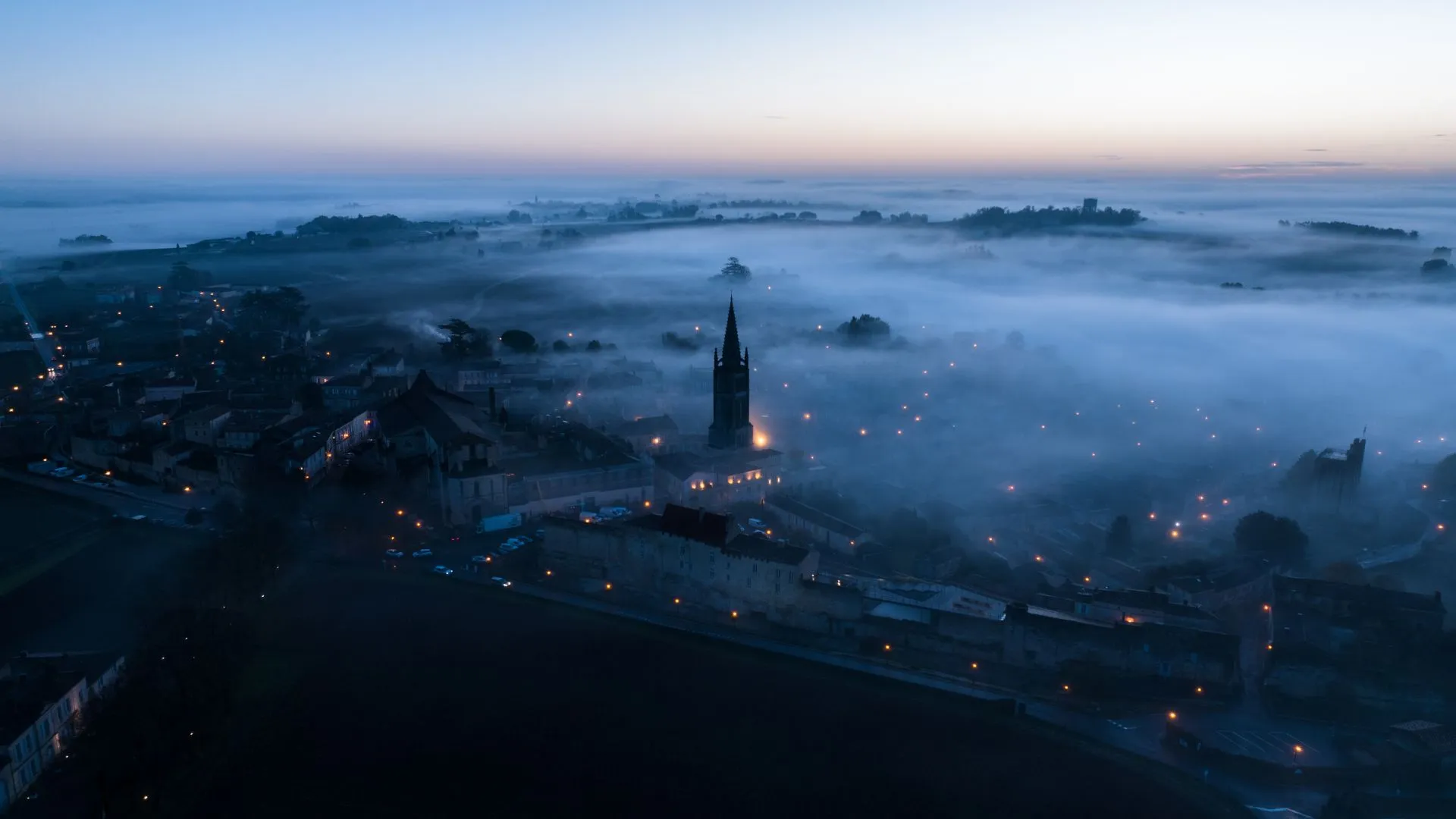 Village dans la brume vu du ciel au lever du jour